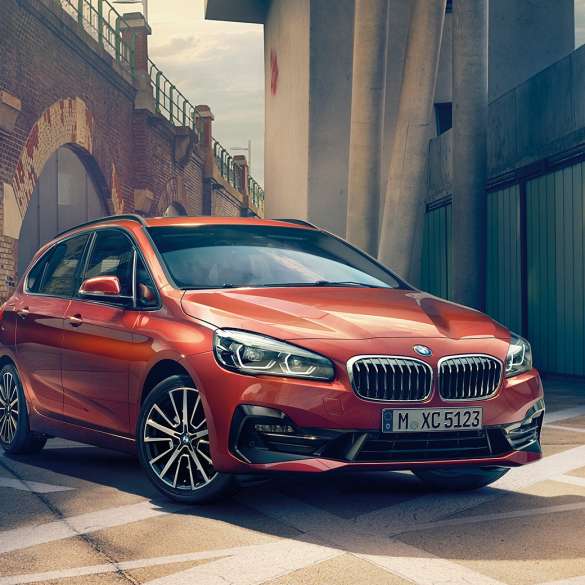Exterior BMW 2 Series Active Tourer BMW 2 Series Active Tourer F45 2018 Sunset Orange metallic three-quarter front view parkend in alley