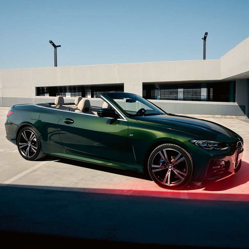 Three-quarter front view BMW 4 Series Convertible G23 2020 with a man BMW 4 Series Convertible G23 Sanremo Green metallic 2020 three-quarter front view with a man next to it