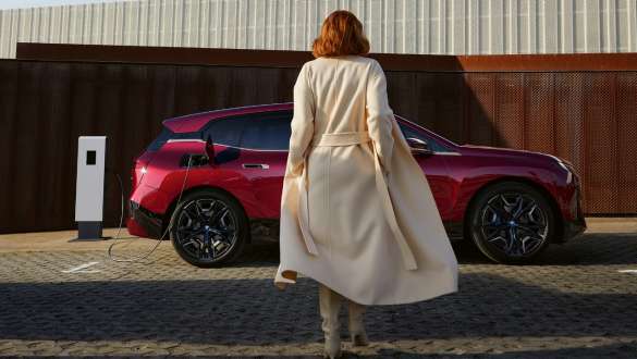 Connected Charging BMW iX M60 i20 2022 electric SUV electric car  BMW iX M60 i20 2022 electric SUV electric car Connected Charging woman in front of BMW iX