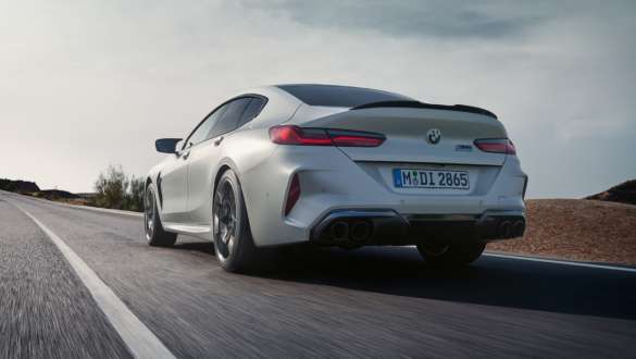 M xDrive BMW M8 Competition Gran Coupé F93 LCI Facelift 2022 BMW M8 Competition Gran Coupé F93 LCI Facelift 2022 BMW Individual Frozen Brilliant White metallic driving rear view low-angle shot M xDrive