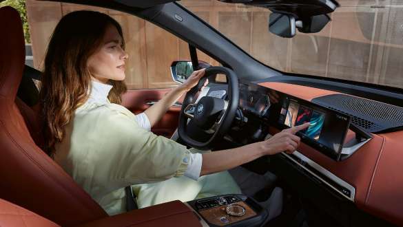 Woman sitting in a BMW iX Electric Car with new BMW iDrive Woman sitting in a BMW iX Electric Car with new BMW iDrive