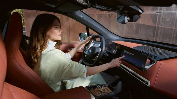 Woman operating display in BMW BMW Teleservices Woman operating display in BMW