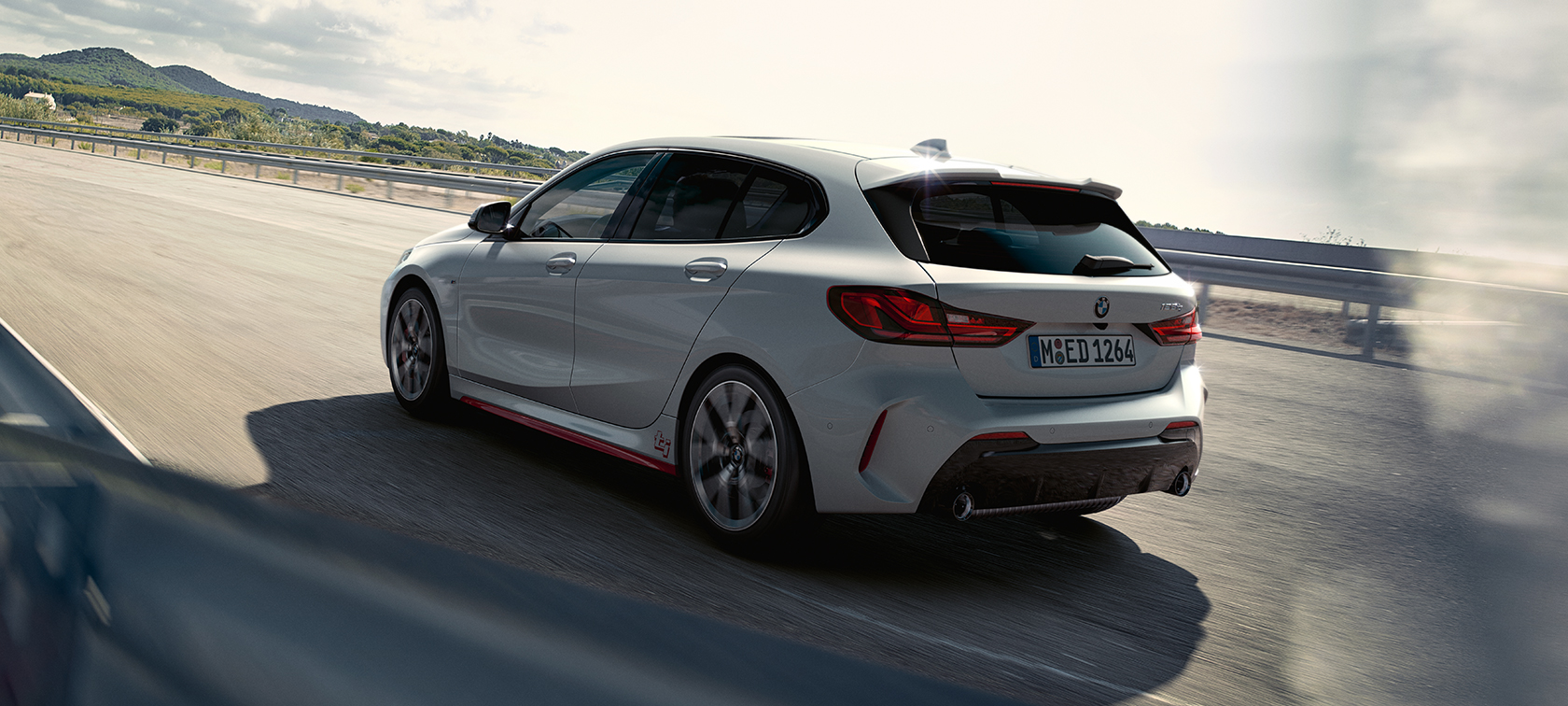 BMW 1 Series 128ti F40 three-quarter rear view driving 