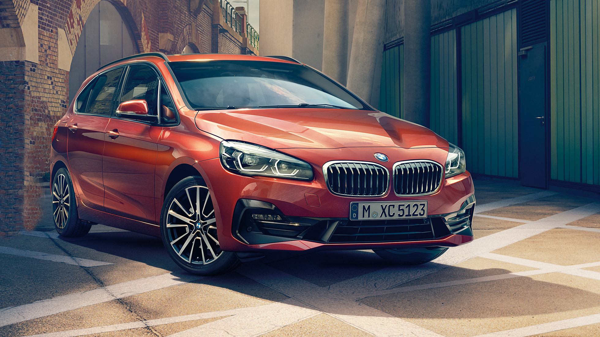 Exterior BMW 2 Series Active Tourer BMW 2 Series Active Tourer F45 2018 Sunset Orange metallic three-quarter front view parkend in alley