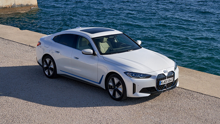 Three-quarter front view BMW i4 eDrive40 G26 2021 at the quay BMW i4 eDrive40 G26 2021 Mineral White three-quarter front view at the quay