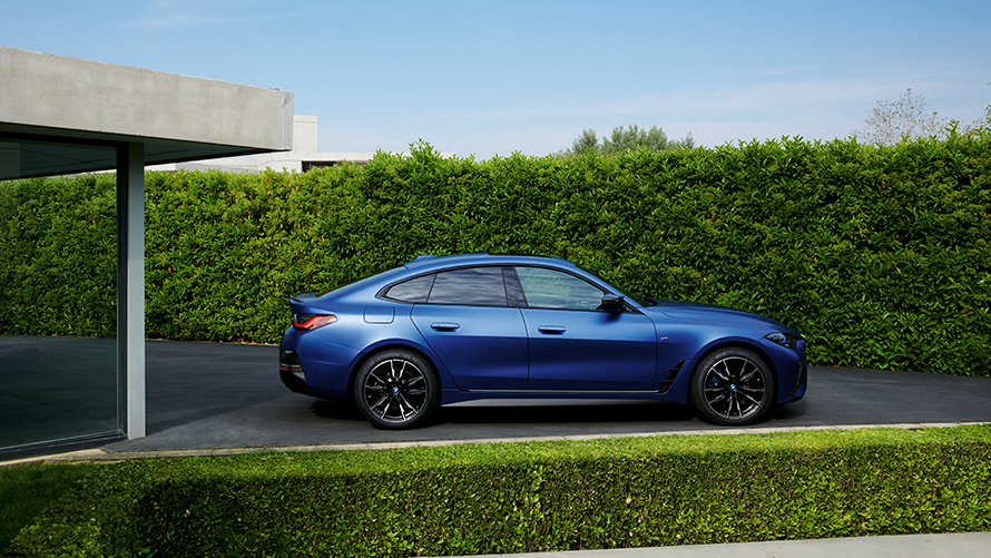 Rear view BMW i4 M50 G26 2021 driving on country road BMW i4 M50 G26 2021 BMW Individual Frozen Portimao Blue metallic rear view driving on country road