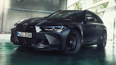 BMW M3 Competition Touring G81 three-quarter front view driving on the street BMW M Series BMW M3 Competition Touring G81 three-quarter front view driving on the street