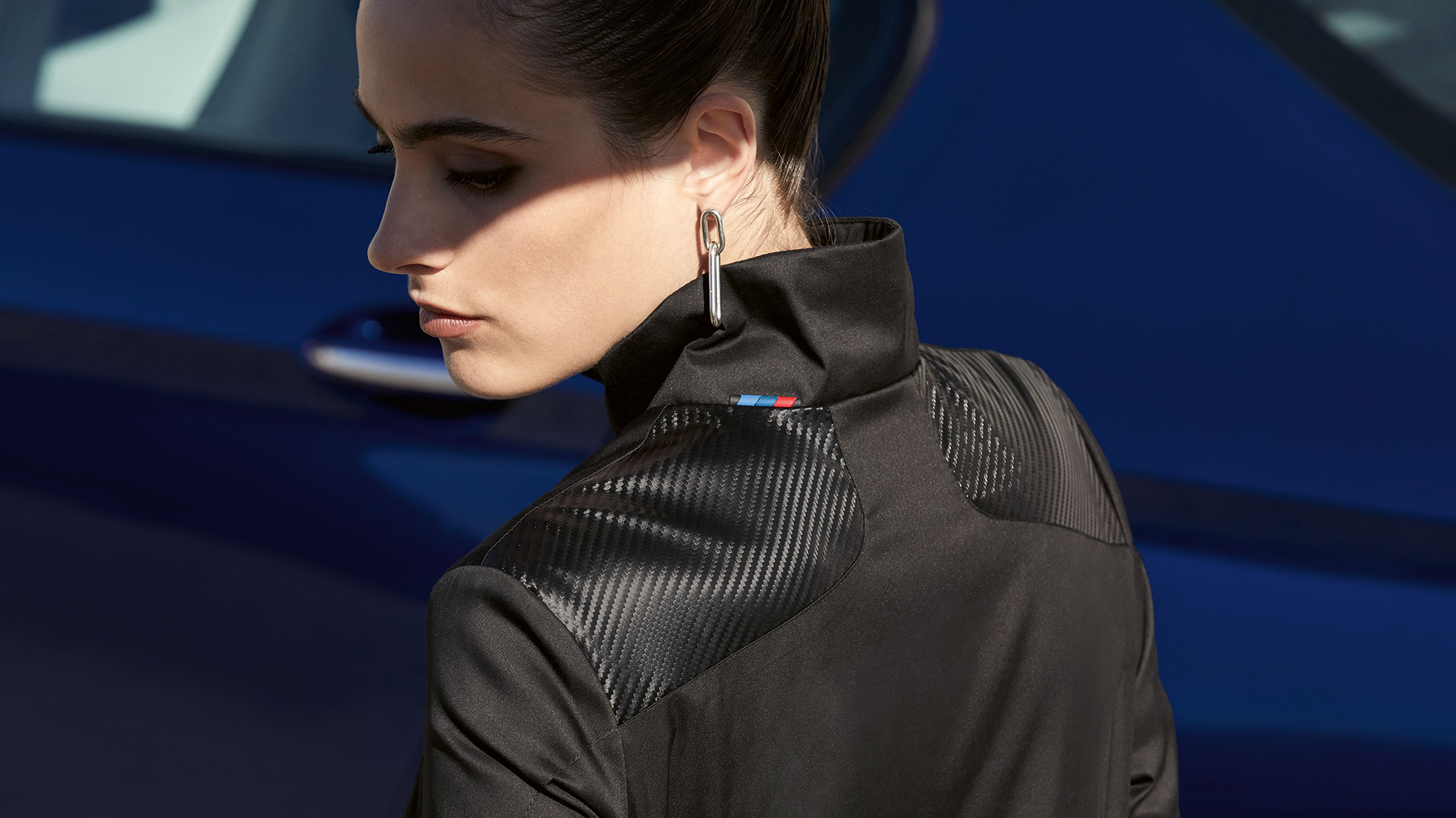 BMW M Jacket, ladies. A female model wearing a BMW M Jacket, ladies looks over her shoulder.